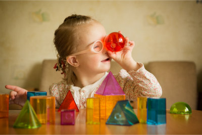 Little girl playing with toys of different shapes